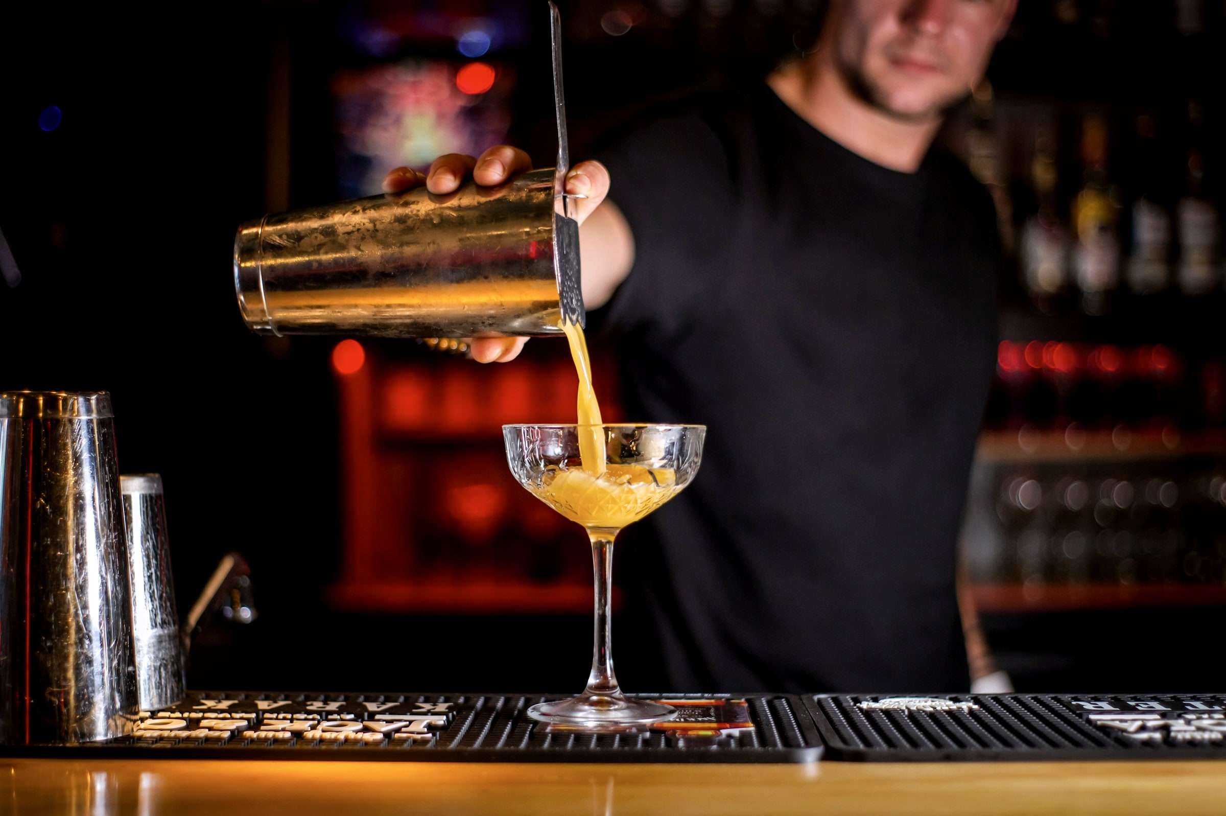 Barkeeper gießt einen Cocktail in ein Glas
