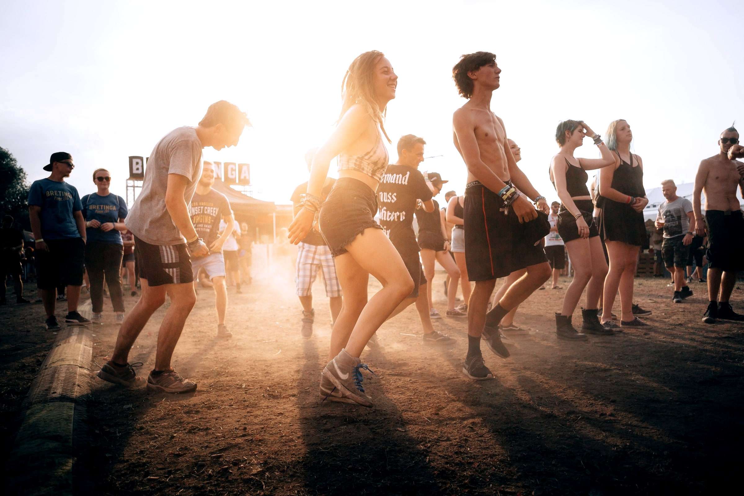 Menschen tanzen bei Sonnenuntergang auf einem Open-Air-Event