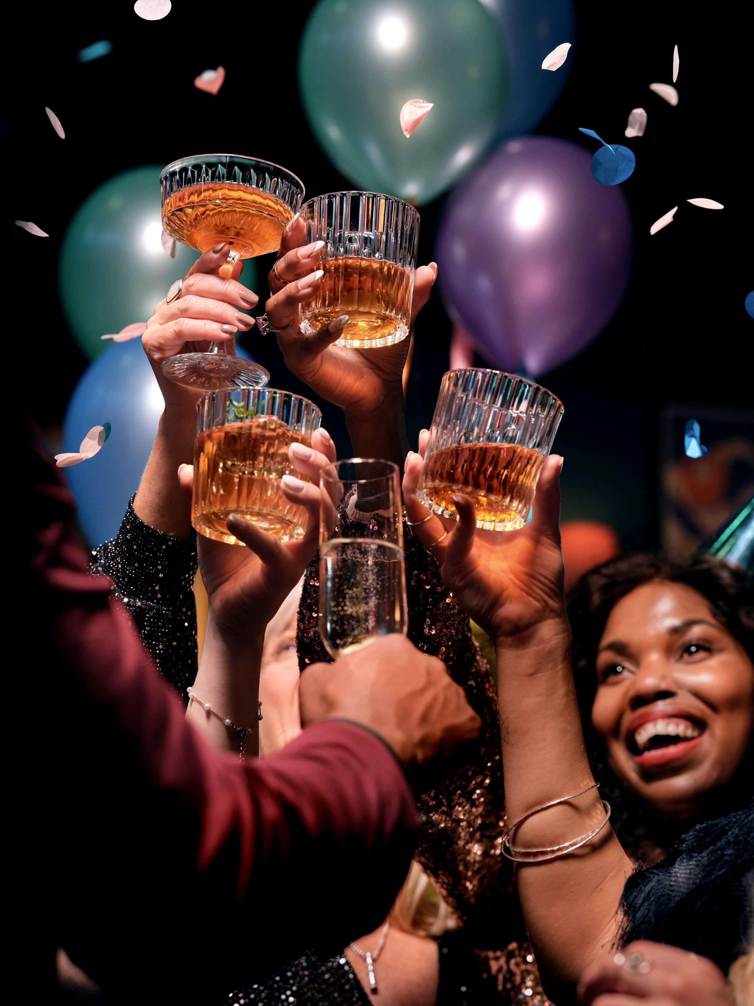 Gruppe stößt mit Konfetti und Ballons an