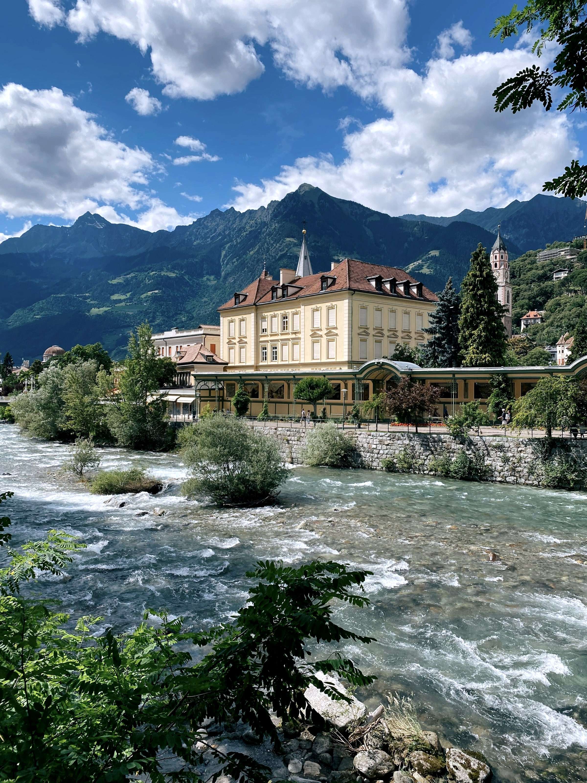 Häuser an der Passer in Meran mit Bergen im Hintergrund
